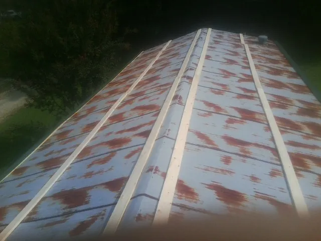 Rusted metal roof panels with new wood purlins before replacement — Storm Damage Roof Repair in Sandy Ridge by Roofing Brothers
