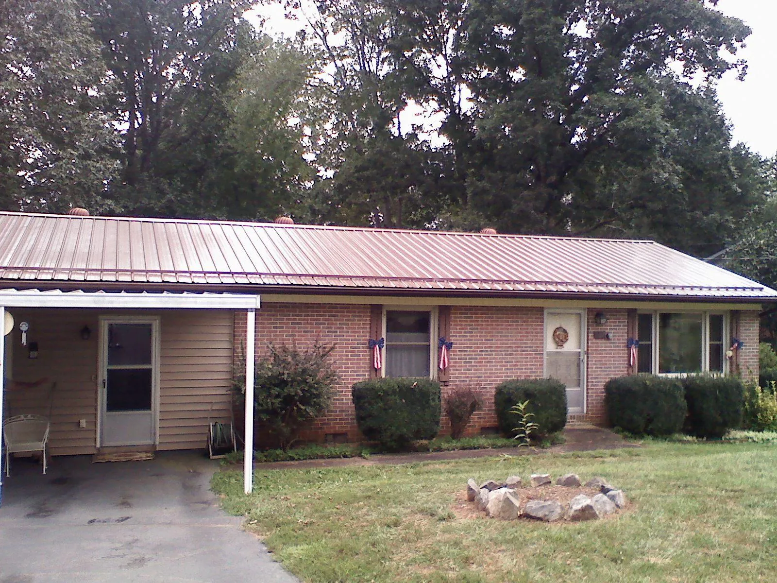 Bronze metal roof and carport on a brick ranch home — Roof Repair work by our crew in Sandy Ridge